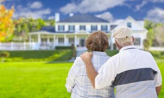 Happy Senior Couple Looking at Front of House photo