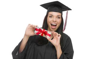Graduada femenina sosteniendo una pila de billetes de cien dólares envueltos para regalo foto