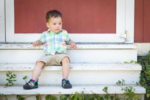 Young Mixed Race Chinese and Caucasian Boy Relaxing On The Steps photo