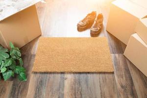 Blank Welcome Mat, Moving Boxes, Shoes and Plant on Hard Wood Floors photo