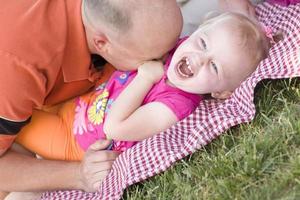 Loving Dad Tickles Daughter in Park photo