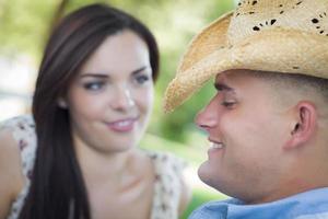 Mixed Race Romantic Couple with Cowboy Hat Flirting in Park photo