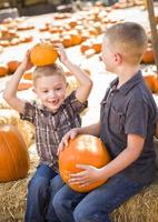 dos niños en el huerto de calabazas hablando y divirtiéndose foto