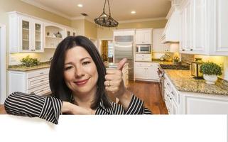 mujer hispana con los pulgares hacia arriba en el interior de la cocina personalizada foto