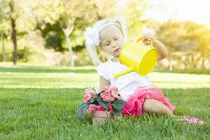 linda niña jugando al jardinero con sus herramientas y maceta. foto