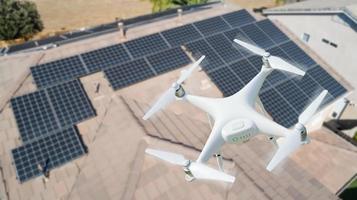 UAV Drone Inspecting Solar Panels On Large House photo