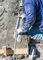 Pool Construction Worker Working With A Smoother Rod On Wet Concrete photo