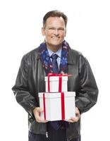 hombre vestido con chaqueta de cuero negro sosteniendo regalos de navidad en blanco foto