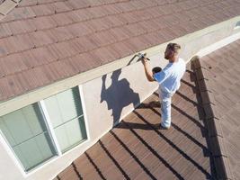 Professional Painter Using A Brush to Paint House Fascia photo