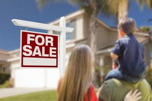 casa y signo de bienes raíces en venta frente a la familia foto