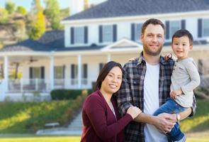 Mixed Race Chinese and Caucasian Parents and Child In Front Yard of New Custom House. photo