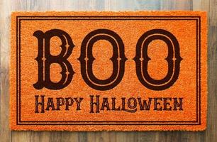 Boo, Happy Halloween Orange Welcome Mat On Wood Floor Background photo