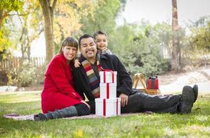Mixed Race Family Enjoying Christmas Gifts in the Park Together photo