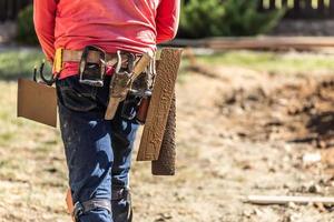 Cement Construction Worker With Toolbelt Holding Various Trowels and Tools On Belt photo