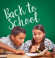 Back To School Written On Chalk Board Behind Hispanic Boy and Girl Having Fun Studying Together photo