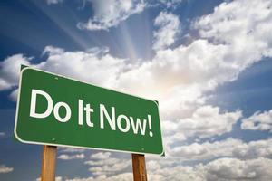 Do It Now. Green Road Sign and Clouds photo