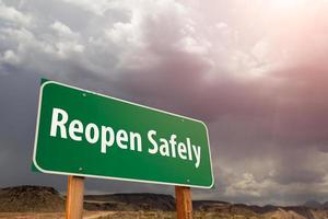 Reopen Safely Green Road Sign Against Ominous Stormy Cloudy Sky photo