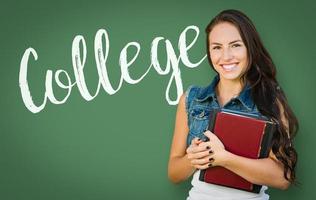 College Written On Chalk Board Behind Mixed Race Young Girl Student Holding Books photo