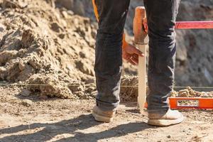 trabajador instalando estacas y guías de madera en el sitio de construcción foto