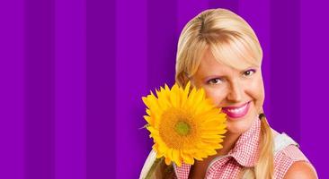 Beautiful Girl Holding Yellow Sunflower Against Purple Striped Background photo