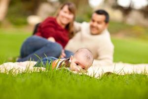 Happy Baby Boy and Mixed Race Parents Playing in the Park photo