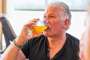 hombre guapo degustando un vaso de cerveza artesanal foto