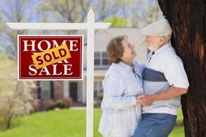 Sold Real Estate Sign with Senior Couple in Front of House photo