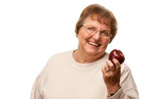 atractiva mujer mayor con manzana roja foto