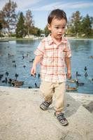 joven chino y caucásico divirtiéndose en el parque y estanque de patos. foto