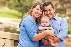 Happy Mixed Race Family Posing for A Portrait in the Park photo