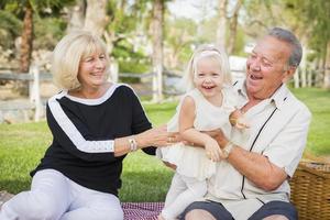 Affectionate Granddaughter and Grandparents Playing At The Park photo