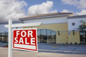 Vacant Retail Building with For Sale Real Estate Sign photo