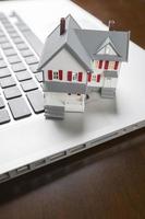 Miniature House on Laptop Computer photo