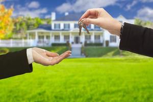 Agent Handing Over House Keys in Front of New Home photo