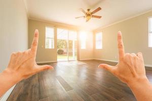 Female Hands Framing Empty Room of House photo