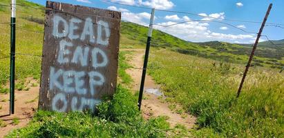 Dead End Keep Out Sign On Wire Fence At Dirt Road photo