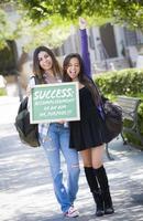 estudiantes de raza mixta sosteniendo pizarra con éxito y definición foto