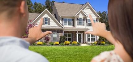 House and Military Couple Framing Hands in Front photo