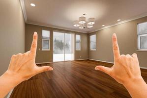 manos femeninas enmarcando la habitación vacía de la nueva casa. foto