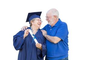 Senior Adult Woman Graduate in Cap and Gown Being Congratulated By Husband Isolated on White. photo