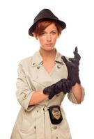 detective femenina con placa y guantes en gabardina en blanco foto