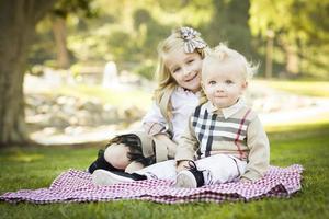 dulce niña con su hermanito en el parque foto