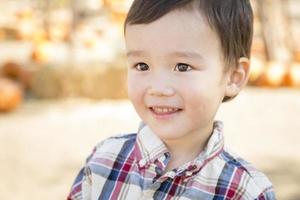 Mixed Race Young Boy Having Fun at the Pumpkin Patch photo