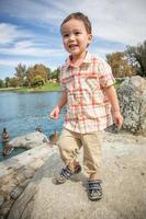 joven chino y caucásico divirtiéndose en el parque y estanque de patos. foto