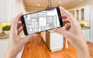 Hands Holding Smart Phone Displaying Drawing of Kitchen Photo Behind