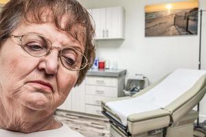 mujer adulta mayor preocupada esperando en el consultorio médico foto