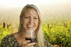 Attractive Woman Enjoying a Glass of Wine at the Vineyard photo