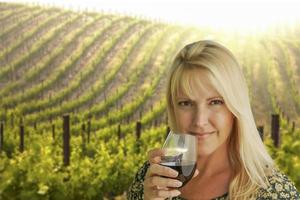 Attractive Woman Enjoying a Glass of Wine at the Vineyard photo