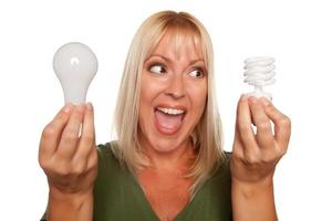 Woman Holds Energy Saving and Regular Light Bulbs photo