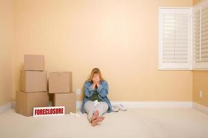 Upset Woman on Floor Next to Boxes and Foreclosure Sign photo